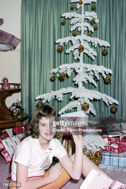 caucasian girl sitting on floor showing christmas gift - archival christmas stock pictures, royalty-free photos & images