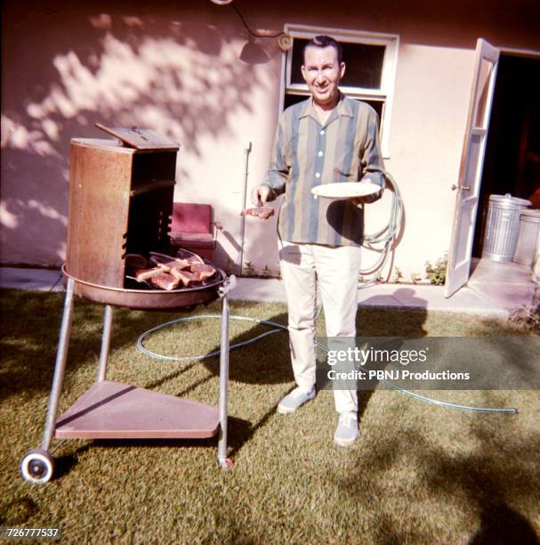 caucasian man cooking meat on barbecue in yard - summer nostalgia stock pictures, royalty-free photos & images