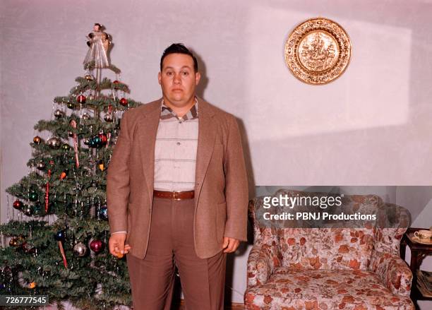 serious caucasian man posing near christmas tree - kitsch bildbanksfoton och bilder