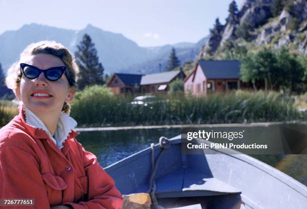 caucasian woman sitting in boat on lake - woman 1950 stock pictures, royalty-free photos & images