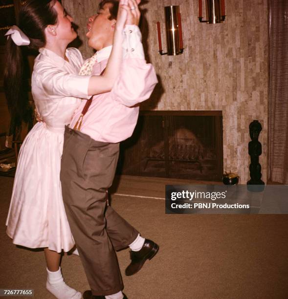 caucasian man and woman dancing near fireplace - man and woman holding hands profile stockfoto's en -beelden