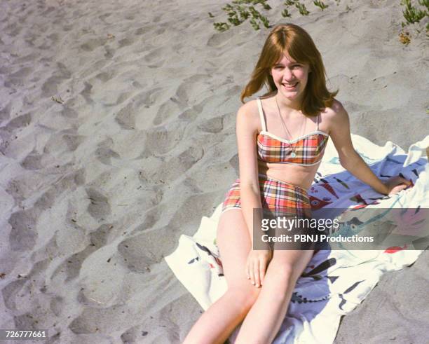 portrait of smiling caucasian teenage girl sitting on blanket at beach - young teen girl beach stock pictures, royalty-free photos & images