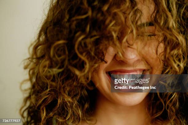 portrait of laughing mixed race woman - curly hair - fotografias e filmes do acervo