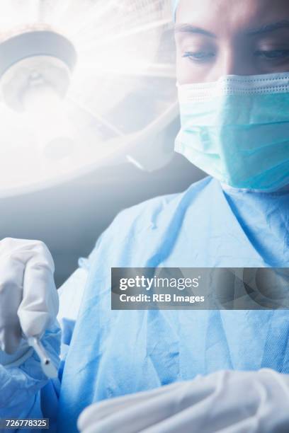 hispanic surgeon holding scalpel - surgical mask stock pictures, royalty-free photos & images