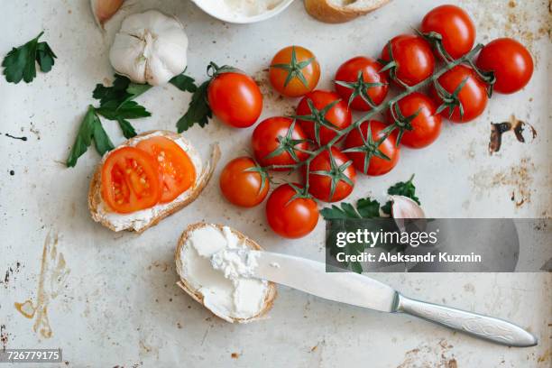 tomatoes on vine near cream cheese and bread - frischkäse stock-fotos und bilder