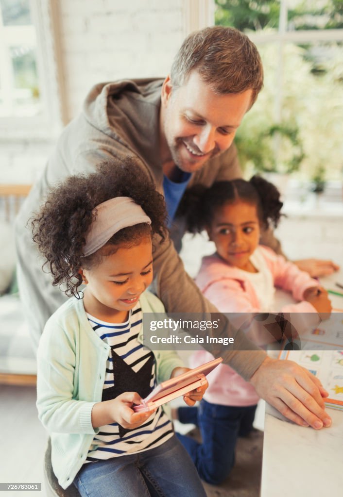 Multi-ethnic father and daughters with digital tablet