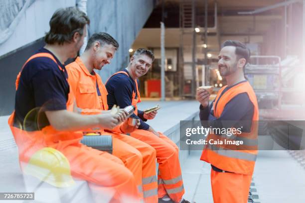 construction workers eating lunch at construction site - food and drink industry stockfoto's en -beelden