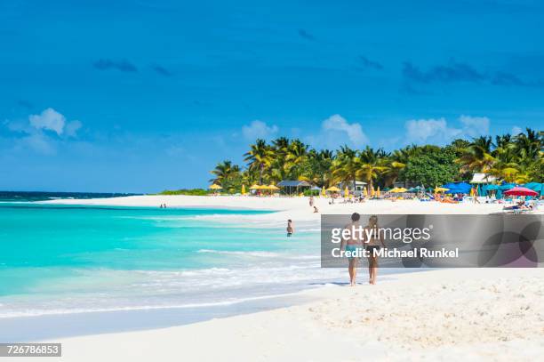 couple walking on world class shoal bay east beach, anguilla, british oversea territory, west indies, caribbean, central america - anguilla photos et images de collection