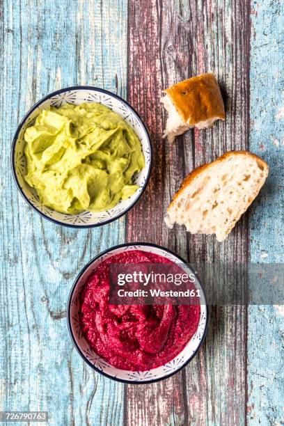 bowls of beetroot hummus and avocado hummus with flat bread - beetroot dip stock pictures, royalty-free photos & images