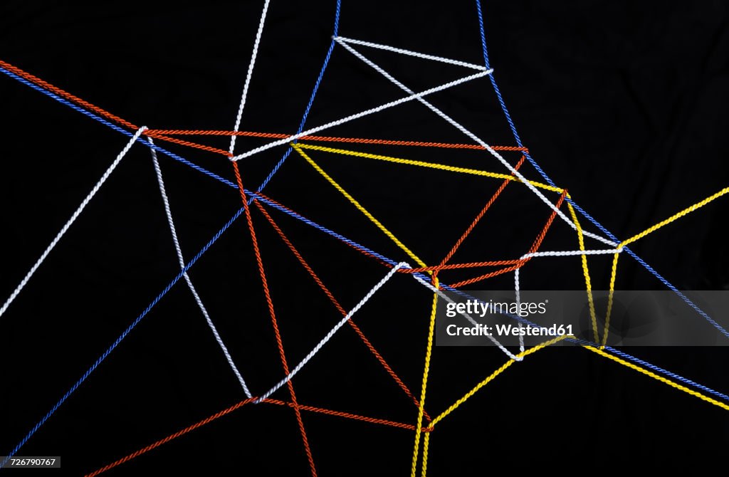 Connected threads in front of black background
