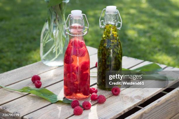 swing top bottles of chopped ramson in olive oil and raspberries in wine vinegar - vinegar stock pictures, royalty-free photos & images