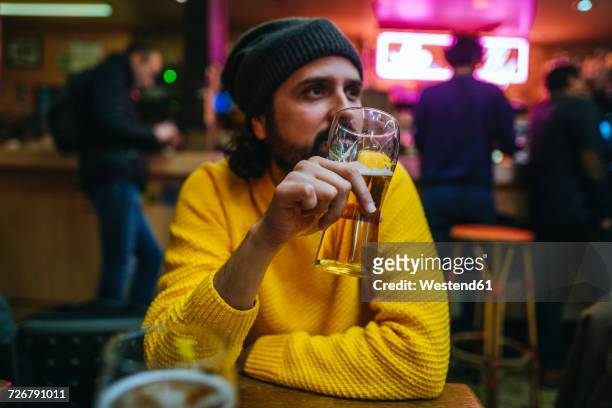 man with glass of beer in a pub - bier dunkel stock-fotos und bilder