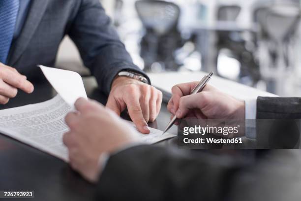 businessman showing client where to sign document - agreement stock-fotos und bilder