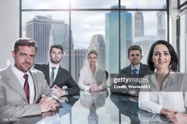 portrait of confident businessmen and businesswomen sitting in conference room - businesswoman nyc stockfoto's en -beelden