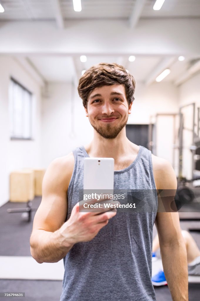 Young athete taking selfies in gym