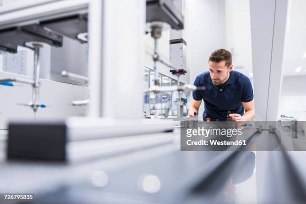 man operating machine in testing instrument room - factory fotografías e imágenes de stock