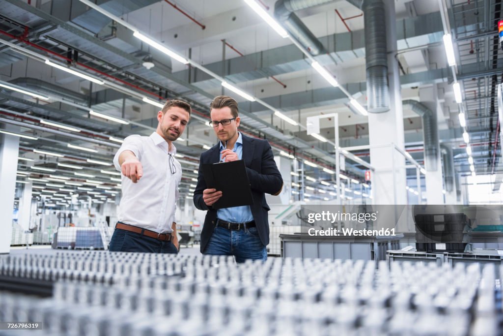 Two men talking in factory shop floor