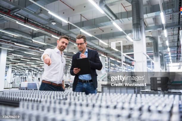 two men talking in factory shop floor - product innovation stock pictures, royalty-free photos & images