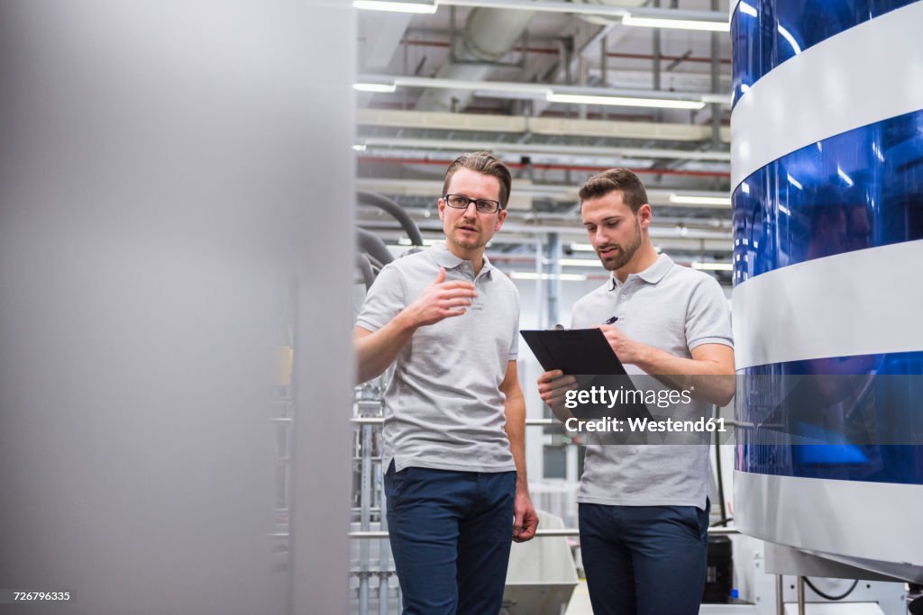 Two Men Talking At Machine In Factory Shop Floor High-Res Stock Photo ...