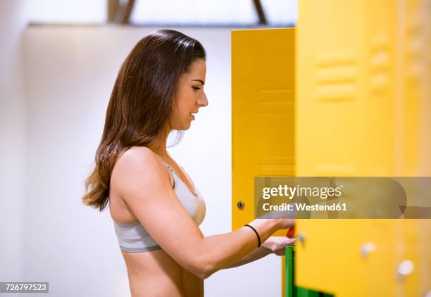 young woman using changing clothes in locker room - vestiaires casier sport photos et images de collection