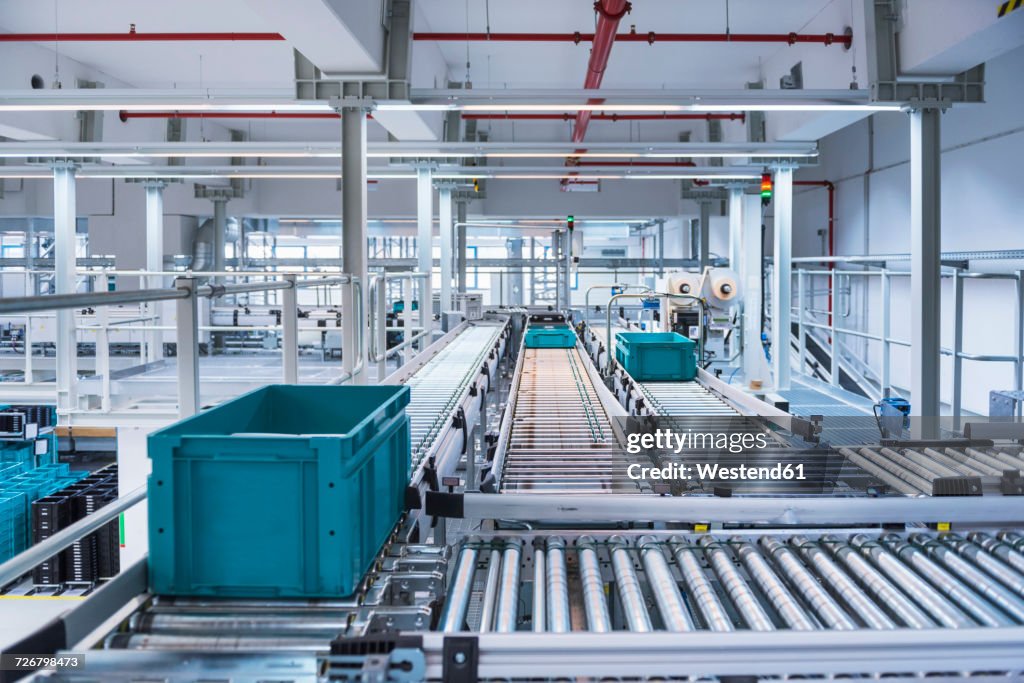 Boxes on conveyor belt in modern automatized high rack warehouse