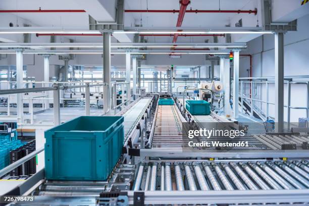 boxes on conveyor belt in modern automatized high rack warehouse - conveyer belt stockfoto's en -beelden