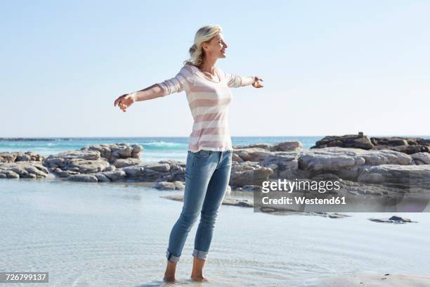matuer woman standing at the sea - mature woman in water stock pictures, royalty-free photos & images