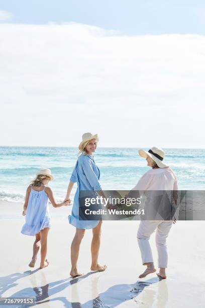 mother, daughter and grandmother walking by the sea, rear view - grandmother and grandchild beach fotografías e imágenes de stock