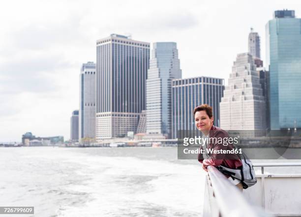 usa, new york city, woman on ferry with manhattan skyline in background - commuter ferry stock pictures, royalty-free photos & images