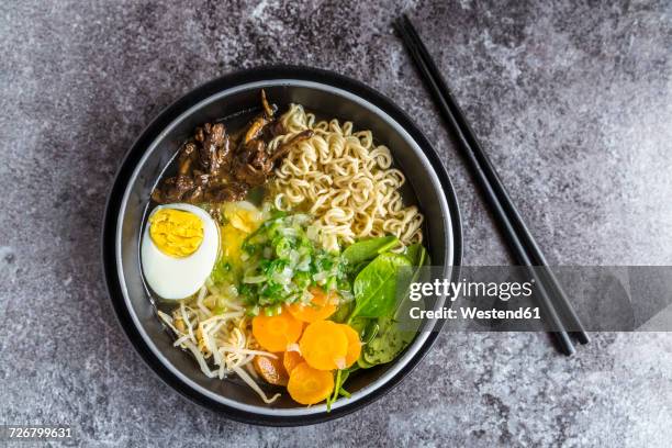 bowl of ramen soup with spinach, carrot, boiled egg, bamboo sprouts and mushrooms - ramen noodles stock pictures, royalty-free photos & images