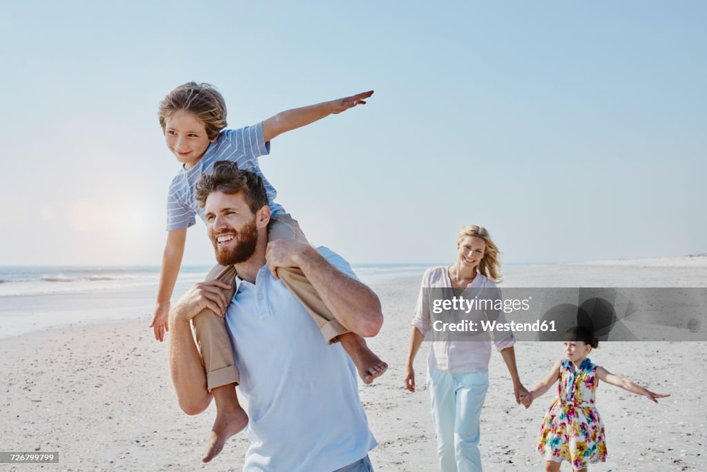 Happy family strolling on the beach