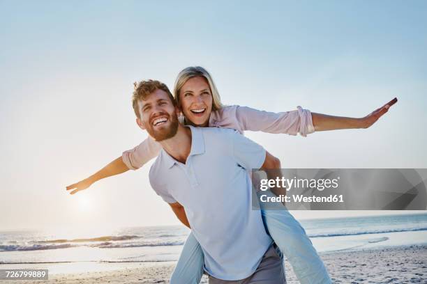 portrait of happy couple on the beach - portrait playful caucasian man foto e immagini stock