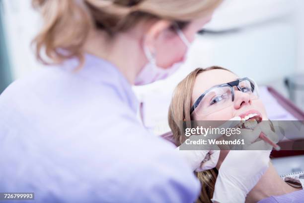 hardening of dental filling at the dentist - tandfyllning bildbanksfoton och bilder