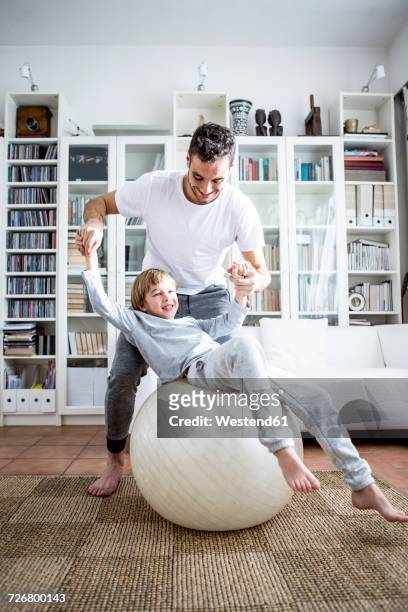 father and son with fitness ball at home - 6 7 jahre stock-fotos und bilder