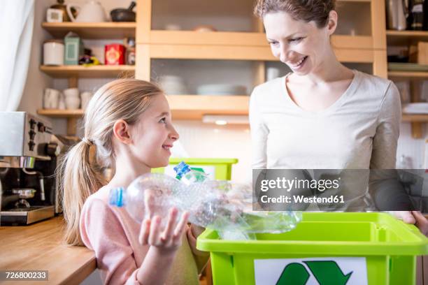 mother and daughter at home separating waste - white trash stock-fotos und bilder