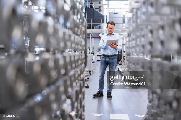 man using tablet in factory shop floor - regarder vers le bas photos et images de collection