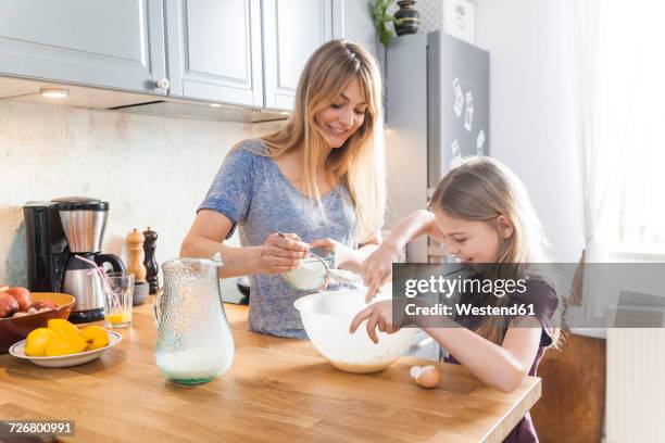 mother and daughter preparing pancakes in kitchen - mother daughter baking stock pictures, royalty-free photos & images