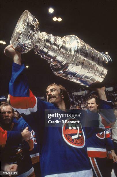 Swedish ice hockey player Bob Nystrom of the New York Islanders celebrates his team's third consectutive Stanley Cup victory by raising the cup...
