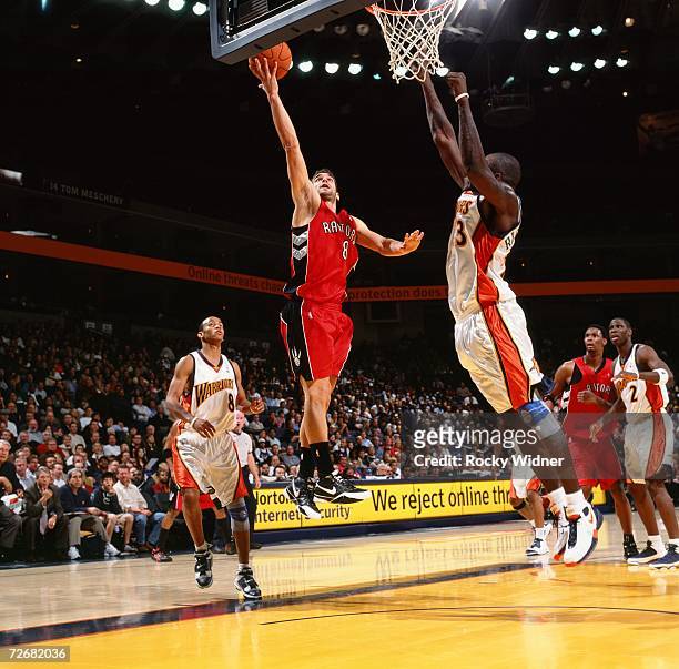 Jose Calderon of the Toronto Raptors takes the ball to the basket shoots a layup against Jason Richardson of the Golden State Warriors during a game...