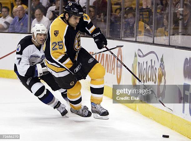 Jason York of the Boston Bruins tries to keep the puck from Tim Taylor of the Tampa Bay Lightning on November 30, 2006 at the TD Banknorth Garden in...