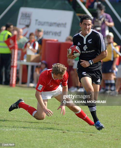 Dubai, UNITED ARAB EMIRATES: New Zealand player Zar Lawrence tries to escape from Tom James of Wales during their Dubai Rugby Sevens match at the...