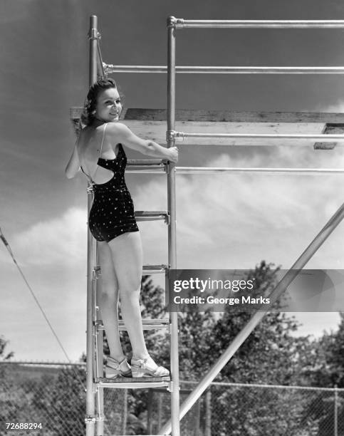 frau stehend auf leiter im springboard, (b & w - women swimming pool retro stock-fotos und bilder