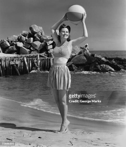 woman holding ball on beach, (b&w) - ouderwets stockfoto's en -beelden