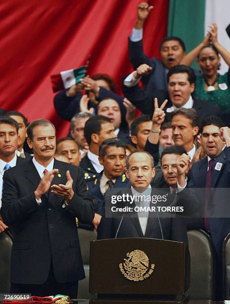 Mexican new President Felipe Calderon is cheered by National Action Party fellows and outgoing President Vicente Fox 01 December, 2006 at the...