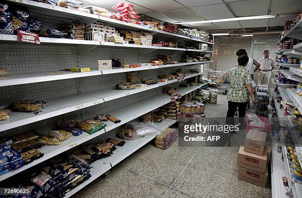 Gondolas aparecen parcialmente vacias cuando venezolanos realizan compras en un supermercado de Caracas el 01 de diciembre del 2006. Los venezolanos...
