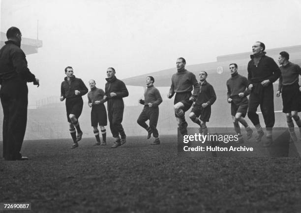 Arsenal footballers training with Tom Whittaker at the club's Highbury Stadium, late 1930s. Players include Jack Crayston, George Male, Ted Drake,...