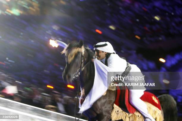 Sheikh Mohammed bin Hamad Al-Thani, captain of the Qatari Endurance Equestrian team, rides a horse to the top of Khalifa stadium to light the...