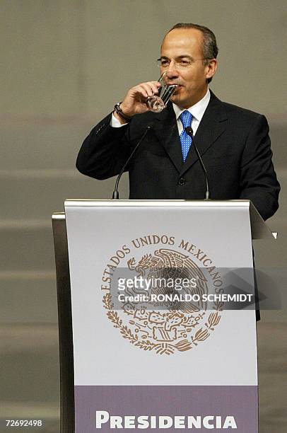Newly inaugurated Mexican President Felipe Calderon drinks some water during his first speech to the people 01 December, 2006 at the National...