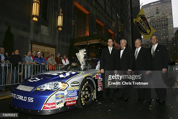 Jimmie Johnson, the 2006 NASCAR Nextel Cup Series Champion, stands with Robert Niblock of Lowe's, his team owner Rick Hendrick, and his crew chief...