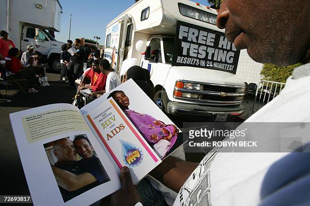 Los Angeles, UNITED STATES: A man reads education literature as he waits for an HIV test at a free mobile testing center in Los Angeles offered by...